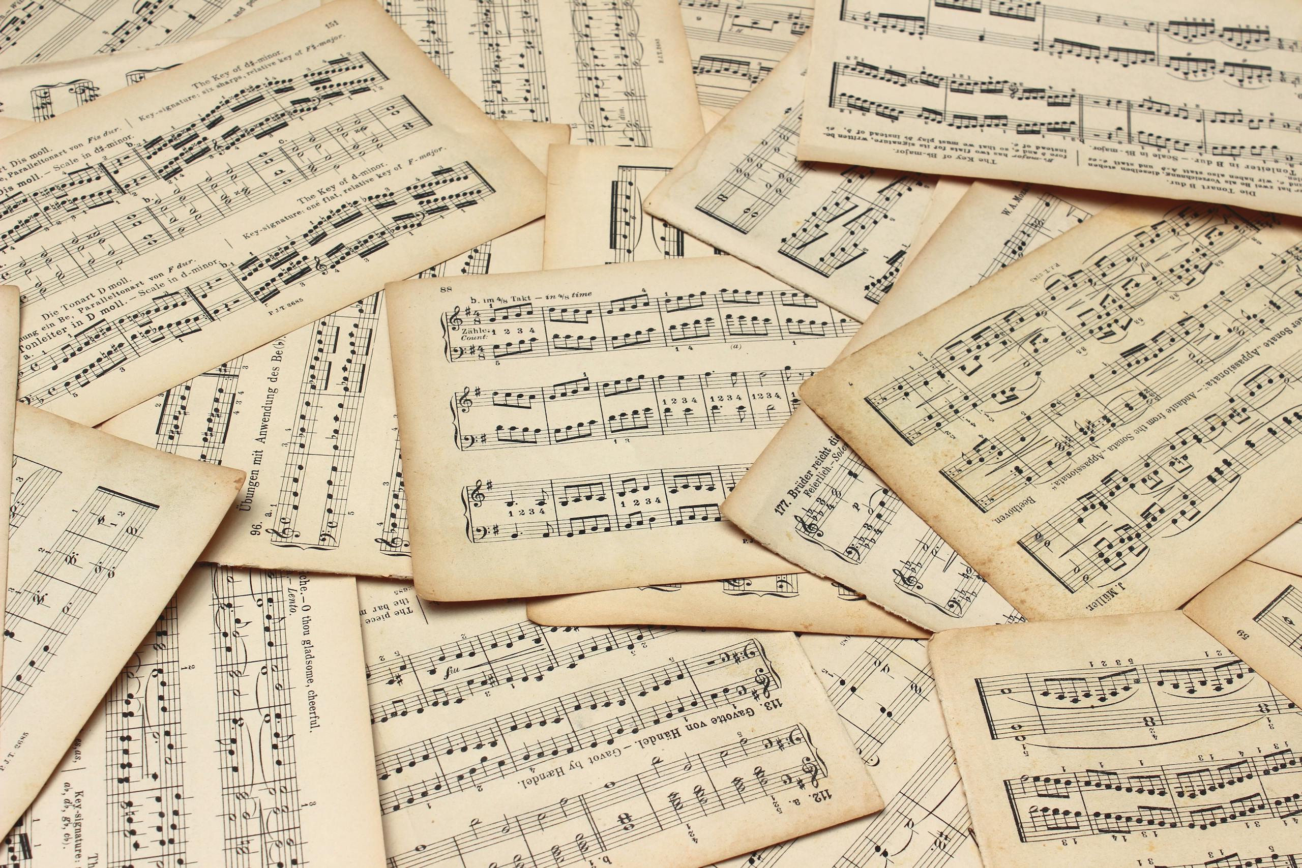 A collection of vintage music sheets scattered artistically, showcasing classic musical notation.